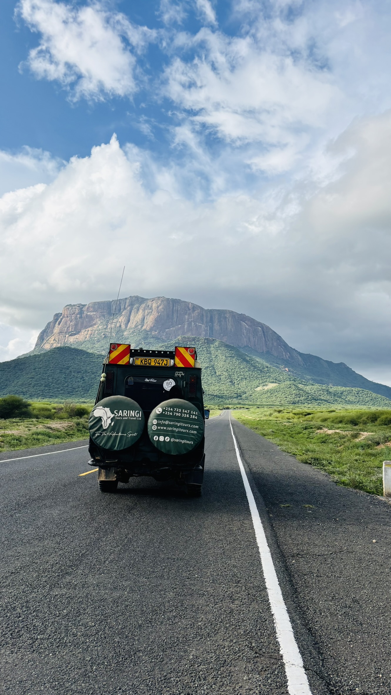 Safari vehicle on a remote road through Kenya's wilderness